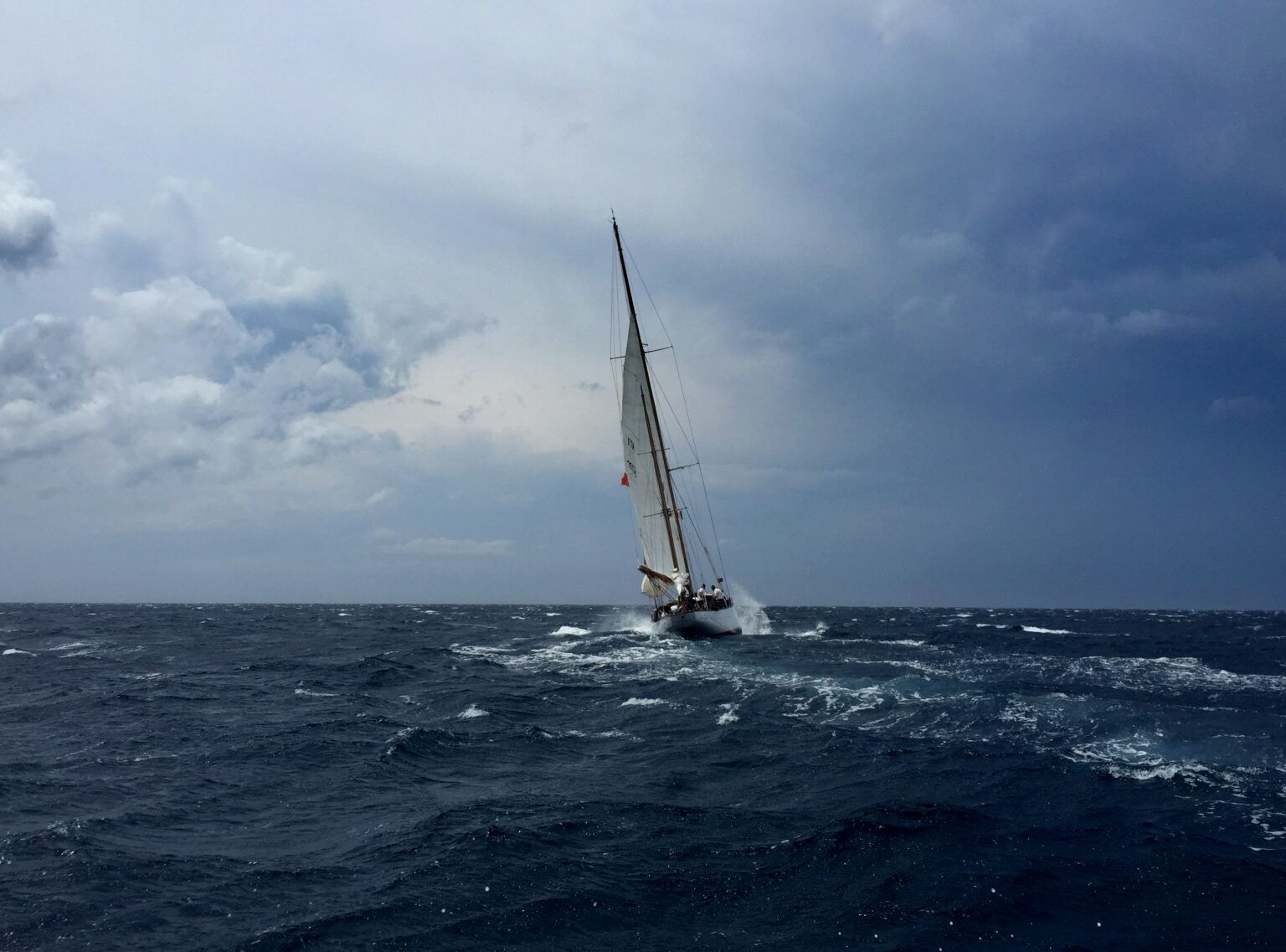 Segelyacht bei rauer See und dramatischem Himmel